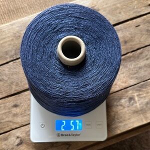 Bright navy blue slub rayon yarn on a cone